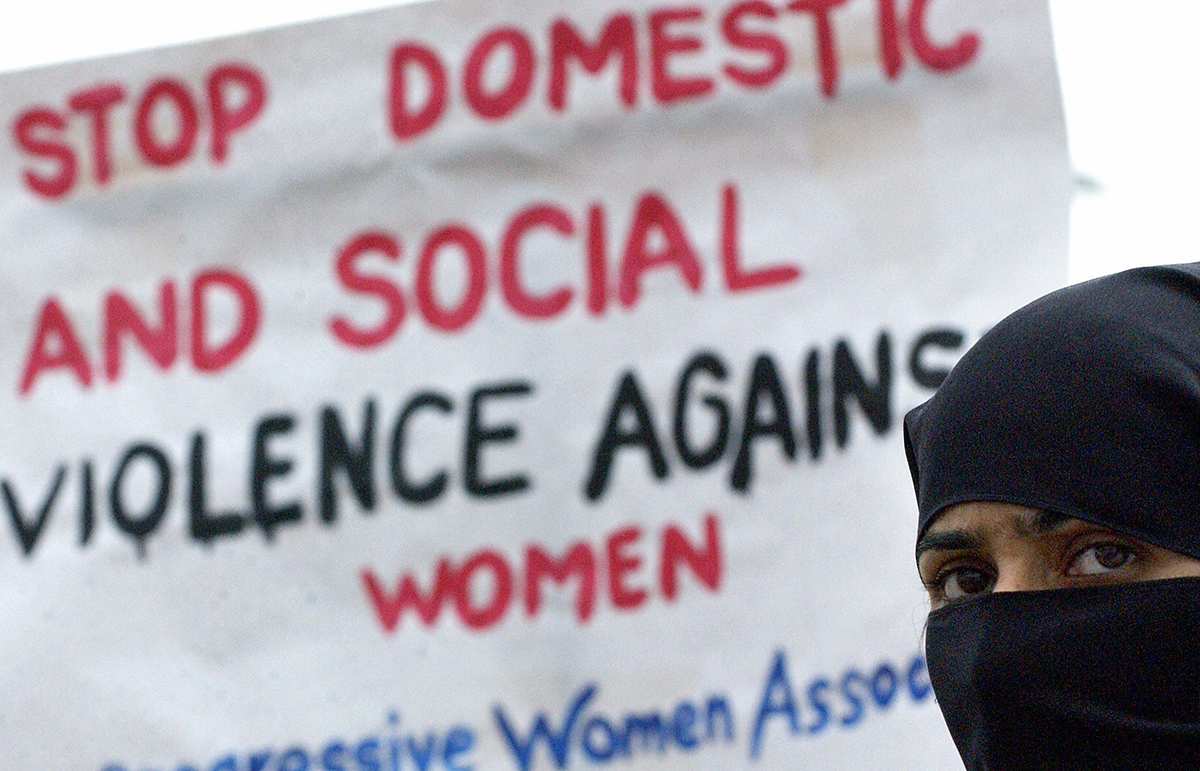 ISLAMABAD, PAKISTAN: A Pakistani woman holds a placard as she marches with other activists of the Progressive Women's Association (PWA) during a demonstration near The Parliament House in Islamabad, 09 March 2004. Some three hundred women took part in the demonstration demanding that the government put a halt to domestic and social violence commited aganist the women of Pakistan. JEWEL SAMAD/AFP/Getty Images