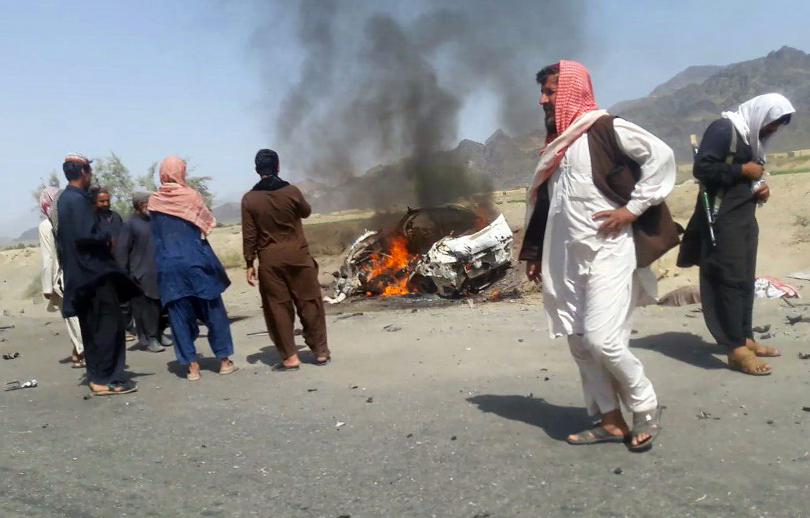  Pakistani local residents gather around a destroyed vehicle hit by a drone strike in which Afghan Taliban Chief Mullah Akhtar Mansour was believed to be travelling in the remote town of Ahmad Wal in Balochistan, around 160 km west of Quetta, May 21, 2016. Photo: Getty Images/AFP 